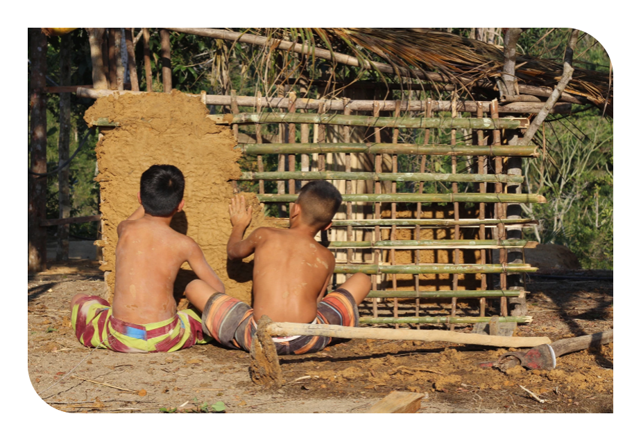 Foto de duas crianças construindo uma parede pau a pique