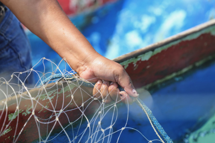 Mulher segurando uma rede de pesca.